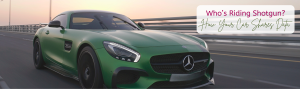 A green, sporty Mercedes is speeding down a highway at sunset.